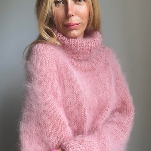 May include: A soft, pink, fuzzy turtleneck sweater.