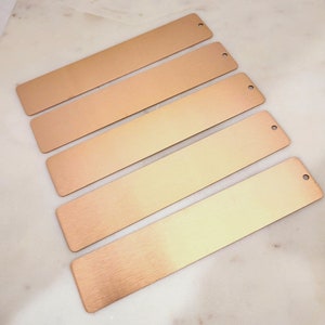 Peut inclure: Cinq marque-pages en métal rose gold avec une finition brossée et un trou en haut.