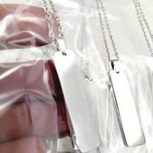 Peut inclure: Trois colliers en argent avec des pendentifs rectangulaires. Les pendentifs sont vierges et lisses.