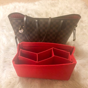 May include: Red felt bag organizer with multiple compartments for a tote bag. The organizer has a rectangular shape and is made of a soft, red felt material.