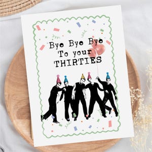 May include: A white rectangular greeting card with a scalloped green border, featuring the black text "Bye Bye Bye To your THIRTIES" above an illustration of five people in black clothing wearing colorful party hats and holding red balloons.