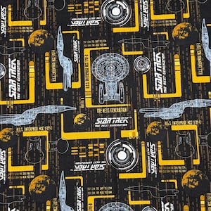 以下が含まれることがあります： 黒色の生地に、Star Trek: The Next Generationの繰り返し模様。デザインには宇宙船、惑星、黄と白のテキスト要素が含まれています。U.S.S. Enterprise NCC-1701-Dが目立っています。