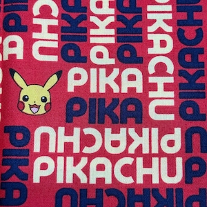 May include: Red fabric with a repeating pattern of the words "Pikachu" and "Pika" in white and navy blue. A yellow Pikachu character is centered in the image.