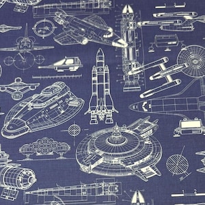 Può includere: Tessuto blu navy con un design a blueprint di veicoli spaziali, tra cui razzi e navette spaziali. I disegni a tratto bianco raffigurano varie navi futuristiche, creando un motivo dettagliato.
