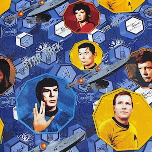 May include: Blue fabric featuring Star Trek characters in octagonal frames. The design includes images of the Starship Enterprise, Starfleet insignia, and the words "STAR TREK". The background is a pattern of blue hexagons.