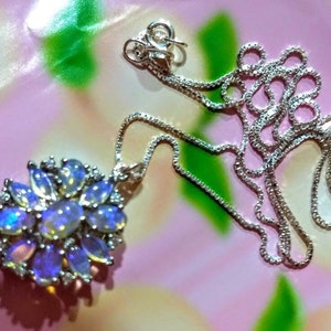 May include: A silver chain necklace with a pendant featuring a cluster of iridescent opal stones set in silver.