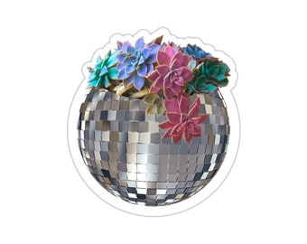 May include: A silver disco ball with a variety of succulents growing out of the top. The succulents are in shades of blue, green, and pink.