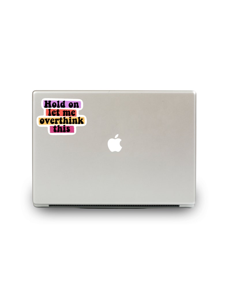 May include: A laptop computer with a sticker that reads "Hold on let me overthink this" in a colourful, retro font.