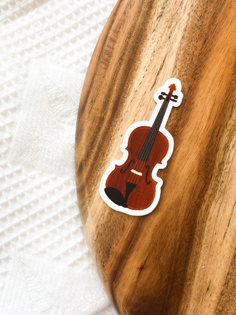 May include: A brown wooden violin sticker on a wooden surface.