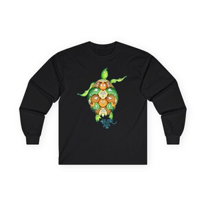 Puede incluir: Camiseta negra de manga larga con un diseño de tortuga colorida. La tortuga tiene cabeza y extremidades verdes, con un caparazón compuesto por varias formas marrones y naranjas. Un gráfico azul y verde está debajo de la tortuga.