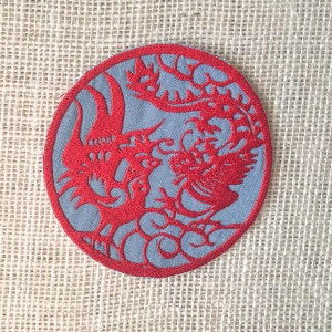 May include: Red embroidered Chinese dragon and phoenix design on a round blue fabric patch.
