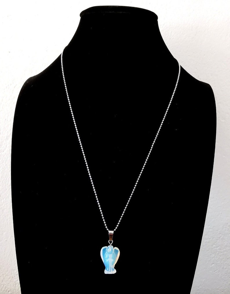 Op de afbeelding: Een zilveren ketting met een blauwe opaal engel hanger.