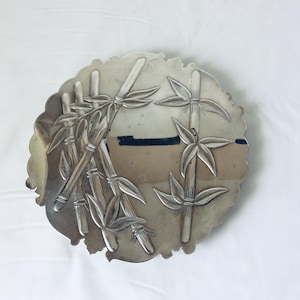 May include: A silver serving dish with an embossed design of bamboo stalks and leaves.