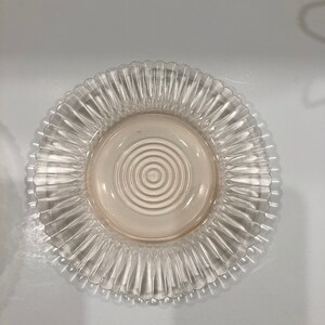 Puede incluir: Plato de vidrio transparente con borde acanalado y zona central con c&iacute;rculos conc&eacute;ntricos. El plato tiene un ligero tono rosado en el centro. Ideal para servir alimentos.
