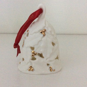 This is a vintage Hallmark Keepsake Ornament from 2000 titled "Holly Berry Bell".  This ornament from 2000 is a decorative Porcelain Holly Berry Bell sculpted by Julie Forsyth.