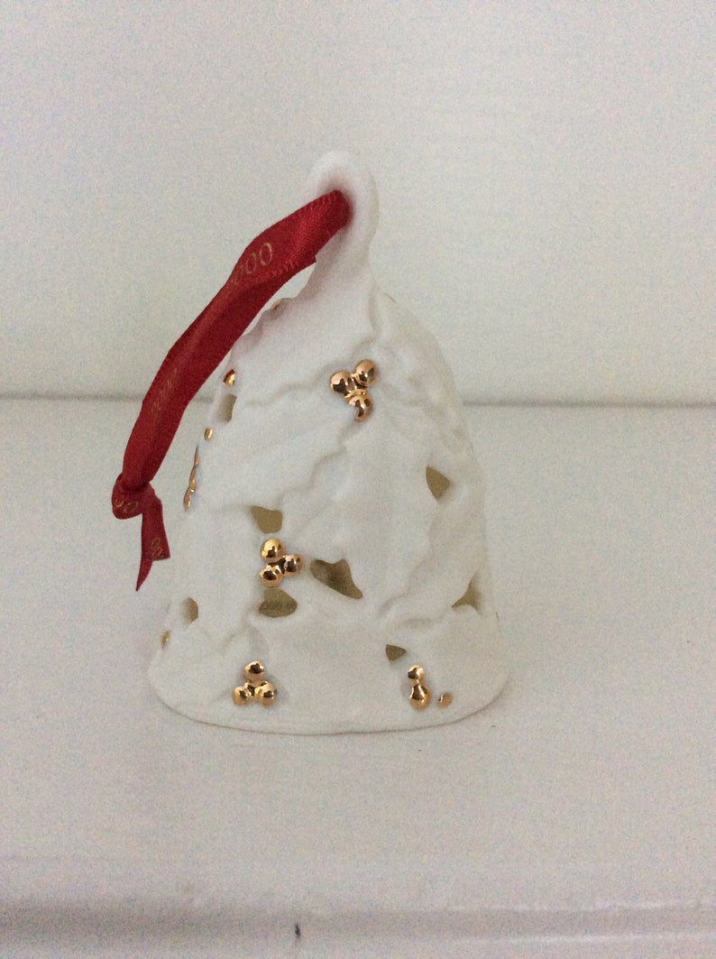 This is a vintage Hallmark Keepsake Ornament from 2000 titled "Holly Berry Bell".  This ornament from 2000 is a decorative Porcelain Holly Berry Bell sculpted by Julie Forsyth.