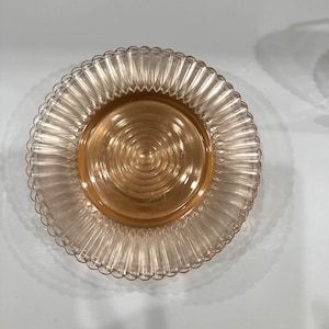 Delicate Petalware Pink by Macbeth-Evans was first made in 1930.  It is a thin, fragile ware with the plates presenting concentric circles from the center and a fine scalloped edge.  These petite plates, measuring 6 3/8" in diameter.