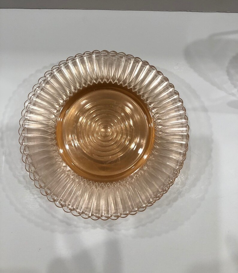 Delicate Petalware Pink by Macbeth-Evans was first made in 1930.  It is a thin, fragile ware with the plates presenting concentric circles from the center and a fine scalloped edge.  These petite plates, measuring 6 3/8" in diameter.