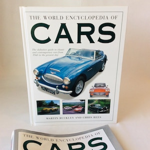 May include: A hardcover book titled The World Encyclopedia of Cars by Martin Buckley and Chris Rees. The white cover features a large blue vintage convertible, a smaller orange car, and three smaller photos of various cars on a white background.