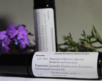 Puede incluir: Un frasco de 10 ml con rodillo, etiquetado como "Remedies by Dr. Hillard Headache/Sinus Relief Roller". La etiqueta enumera los aceites esenciales de la mezcla: Menta piperita, Lavanda, Incienso, Eucalipto y Aceite de coco fraccionado. También indica "Para obtener los mejores resultados, aplicar 2-3 veces al día."