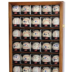 May include: A wooden display case containing 36 baseballs. The baseballs are in clear plastic cases and are signed by various players. The case has a dark wood frame and a glass front.