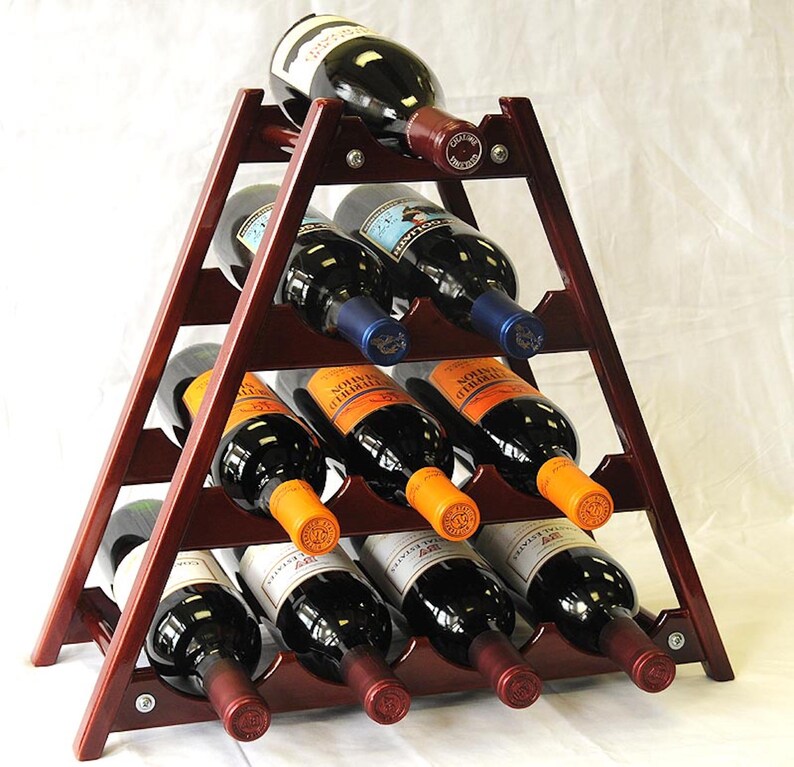 May include: A wooden wine rack with a triangular shape, holding 12 bottles of wine. The rack is made of dark wood and has a natural finish. The bottles are arranged in rows, with the top row being the most visible. The bottles are all different colors and have different labels.
