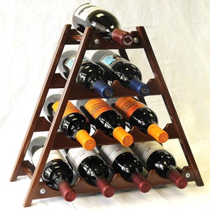 May include: A wooden wine rack in the shape of a triangle with 10 slots for bottles. The rack is brown and has a natural wood finish. The rack is filled with wine bottles of various colors and labels.