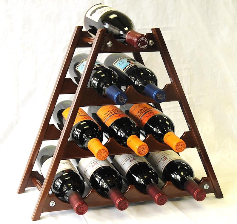 May include: A wooden wine rack in the shape of a triangle with 10 slots for bottles. The rack is brown and has a natural wood finish. The rack is filled with wine bottles of various colors and labels.