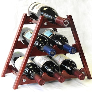 May include: A wooden wine rack with a triangular shape and six slots for bottles. The rack is made of dark wood and has a natural finish. The rack is filled with six bottles of wine, all with different labels.
