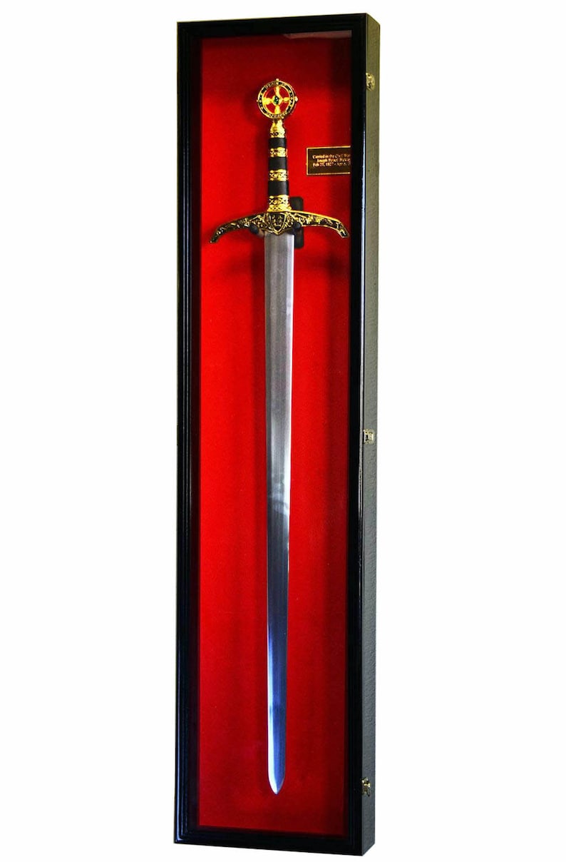 May include: A decorative sword in a black display case with a red velvet backing. The sword features a silver blade, a gold-colored hilt with intricate designs, and a black handle. The top of the hilt has a red and gold emblem.