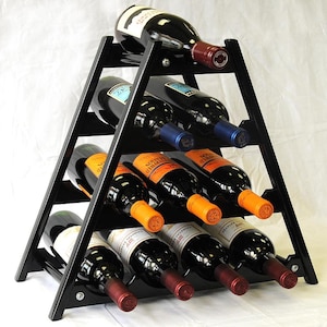 May include: Black wooden wine rack with a triangular shape and six shelves. The rack is filled with bottles of wine, some with orange labels and some with blue labels.