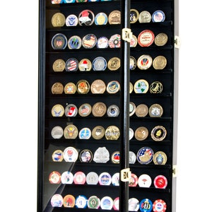 May include: Black wooden display case with glass doors for storing and displaying coins or challenge coins. The case has 36 slots and is open to reveal the coins inside.