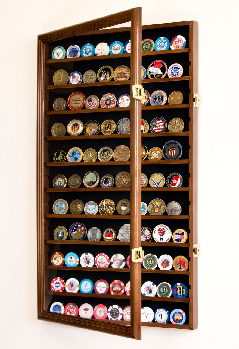 May include: A wooden display case with glass doors for storing and displaying coins or tokens. The case has 18 shelves and is filled with a variety of coins and tokens.