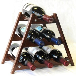 May include: A wooden wine rack with a triangular shape and six slots for bottles. The rack is made of dark brown wood and has a natural finish. The rack is holding six bottles of wine, all of which are red wine.