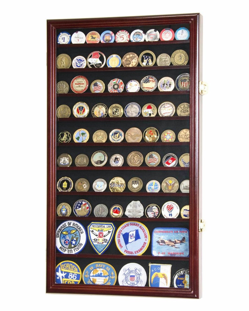 May include: A mahogany wood shadow box display case with a black felt background and glass front. The case is filled with various military challenge coins and patches. The patches include the United States Coast Guard Auxiliary, the Confederate Air Force, and the Warriors of America.