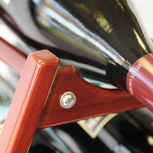 May include: A close-up of a wooden wine rack with a bottle of wine resting in the rack. The bottle is labeled "Grown Estate".