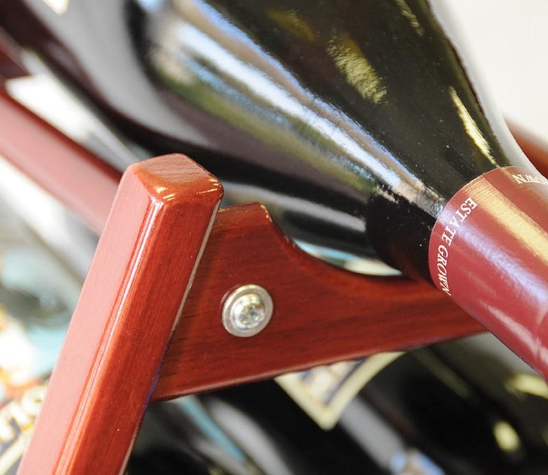 May include: A close-up of a wooden wine rack with a bottle of wine resting in the rack. The bottle is labeled "Grown Estate".