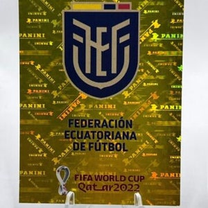 Puede incluir: Una pegatina Panini con el escudo de la Federaci&oacute;n Ecuatoriana de F&uacute;tbol en un escudo azul marino con una parte superior amarilla y roja. La pegatina tiene un fondo hologr&aacute;fico dorado con el texto "PANINI". Tambi&eacute;n es visible el logotipo de la Copa Mundial de la FIFA Qatar 2022.