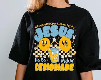 May include: Black t-shirt with a graphic featuring two cartoon lemons holding hands, a glass of lemonade, and the text "Life Gave Me Some Lemons, But My JESUS He Be Makin' LEMONADE."