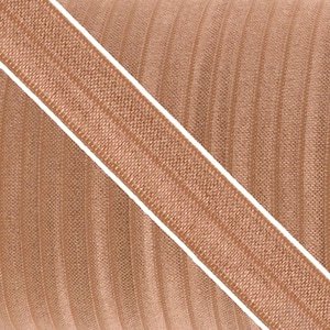 Op de afbeelding: Een close-up van een bruine geribbelde stof met een diagonale strook van dezelfde stof. De stof heeft een subtiele glans.