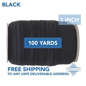 Op de afbeelding: Een rol van 91,4 meter zwarte elastiek, 2,5 cm breed. De elastiek is gewikkeld rond een kartonnen kern. Het label zegt "1 INCH 25mm" en "100 YARDS".