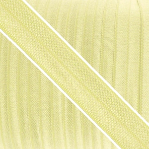 May include: A roll of light yellow elastic ribbon featuring a textured surface with vertical ribbed lines. The band is characterized by a consistent woven pattern and a distinct diagonal orientation across the frame, showcasing its flexible material.