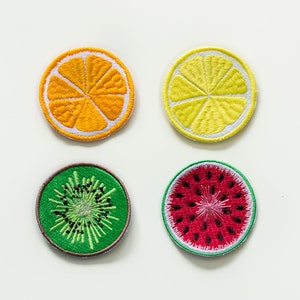 Può includere: Quattro toppe ricamate da stirare con fette di frutta: un limone giallo, un'arancia arancione, un kiwi verde e un'anguria rossa.