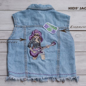 Op de afbeelding: Een blauwe denimvest met een paars en zwart geborduurd beeld van een meisje dat gitaar speelt. De vest heeft een groen en paars geborduurd patch met de tekst "KIDS' JACKET" en de woorden "DIRECT EMBROIDERY" en "EMBROIDERY PATCH" staan op de afbeelding.