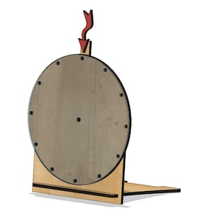 Könnte beinhalten: Ein hölzernes Glücksrad mit einer braunen runden Basis und einem Holzständer. Das Rad ist so konzipiert, dass es sich mit einem roten Pfeil nach unten dreht.