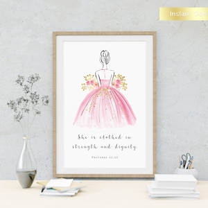 Peut inclure: Une impression d'art imprimable représentant une illustration aquarelle d'une femme en robe rose avec des accents de paillettes dorées. Le texte "She is clothed in strength and dignity. Proverbs 31:25" est sous l'illustration.