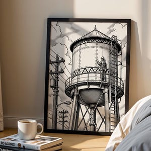 May include: A framed black and white line art print depicting a large industrial water tower with a person standing on the maintenance platform, surrounded by utility poles and clouds, presented in a simple black frame on a wooden floor.