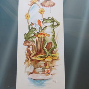 May include: A vertical print illustration featuring two green frogs in a pond setting. One frog sits on a mushroom using a brush, while the other stands before an oval mirror holding a hand mirror. A lamp hangs above, and the artist signature Coby is visible.