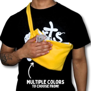 May include: A person wearing a black t-shirt with a white graphic on it is holding a yellow fleece pet carrier with a small gray rat inside. The carrier has a strap that goes over the person's shoulder. The text on the t-shirt says "Rats". The text below the carrier says "MULTIPLE COLORS TO CHOOSE FROM!"