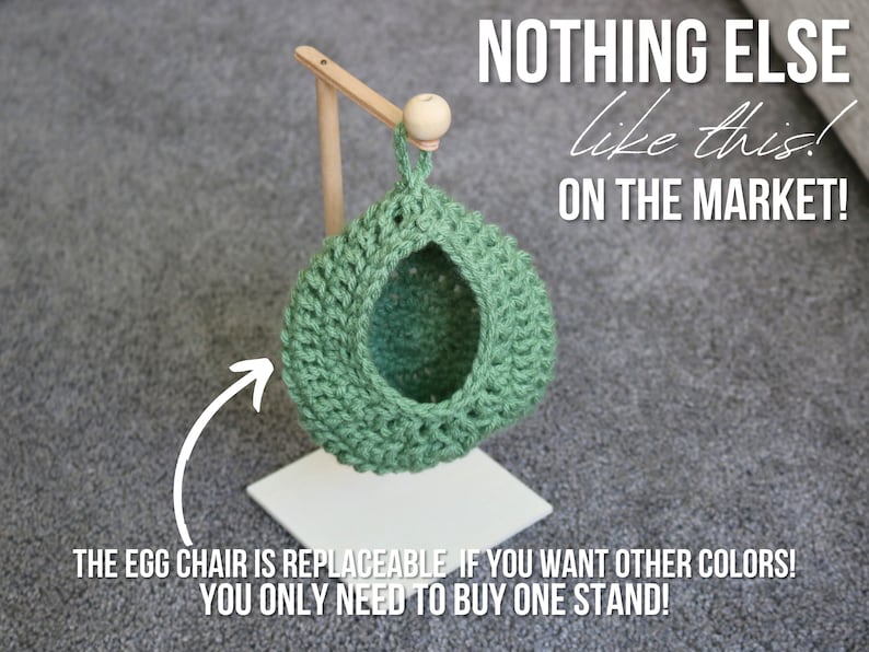 May include: A green crocheted egg chair hanging from a wooden stand. The stand is white and has a round wooden knob at the top. The text "NOTHING ELSE like this! ON THE MARKET!" is written in black on a white background. The text "THE EGG CHAIR IS REPLACEABLE IF YOU WANT OTHER COLORS! YOU ONLY NEED TO BUY ONE STAND!" is written in black on a white background.